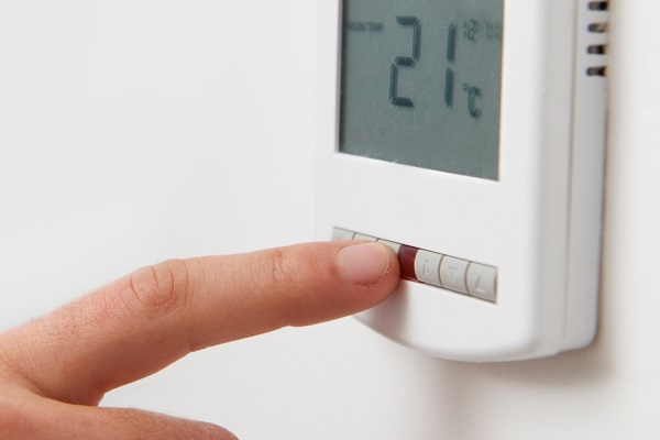 homeowner adjusts thermostat settings